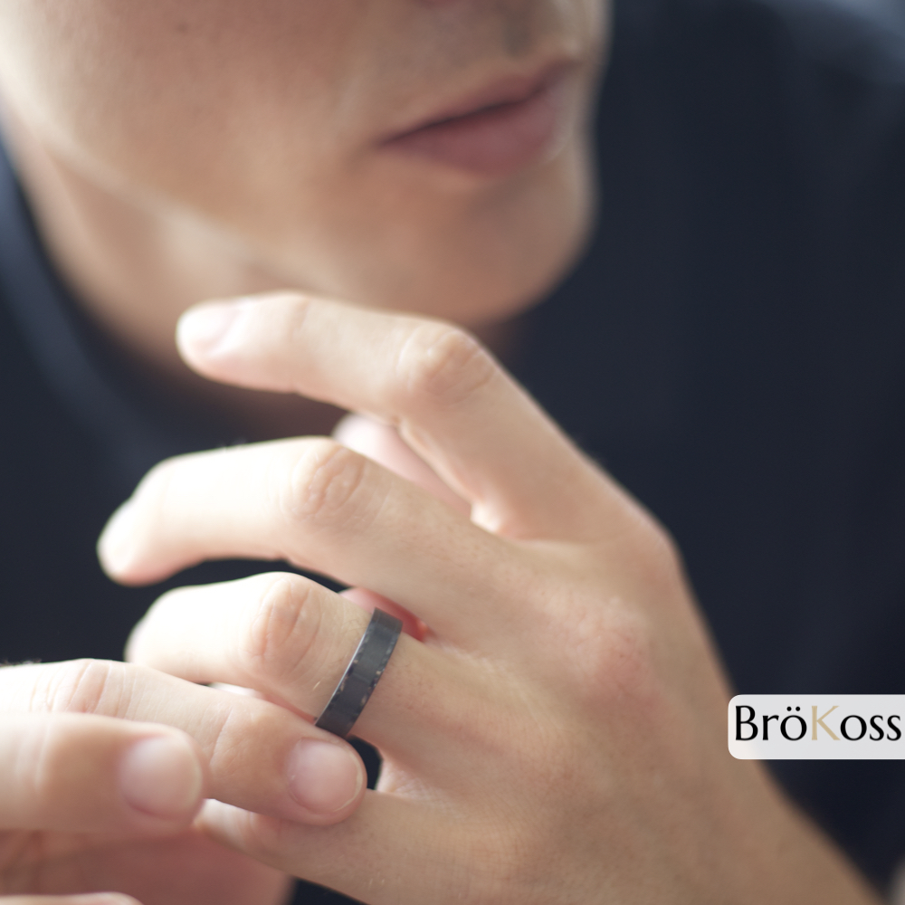Anillo negro de hombre de zirconio en mano, demostrando estilo, presencia y elegancia masculina
