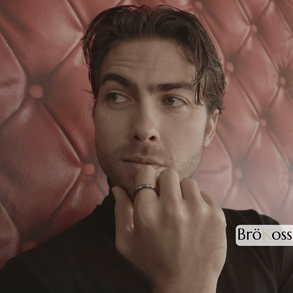 Anillo de compromiso de hombre, modelo posando con anillo de zirconio negro y gris con diamante, diseño elegante y contemporáneo