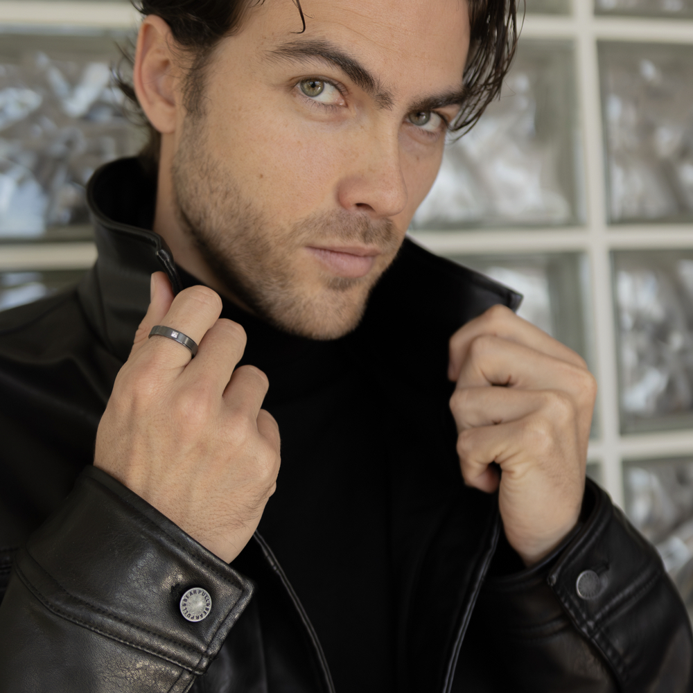 Anillo brillante hombre en zirconio negro con brillante cuadrado y bordes pulidos en mano de modelo masculino elegante