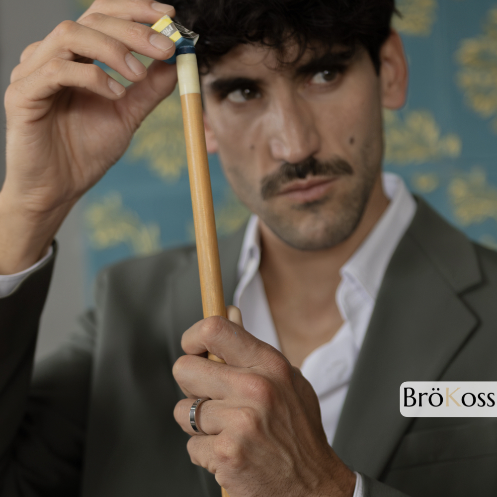 Anillo con piedra negra, modelo sosteniendo palo de billar con anillo de zirconio gris y diamante negro, diseño sofisticado y contemporáneo