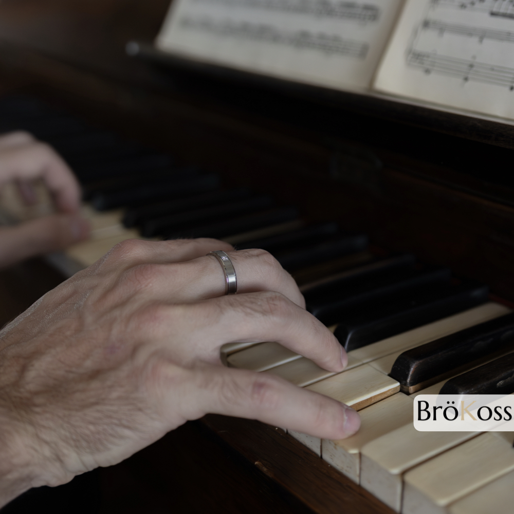 Anillo de diamante para hombre, detalle en mano tocando piano, lujo y elegancia