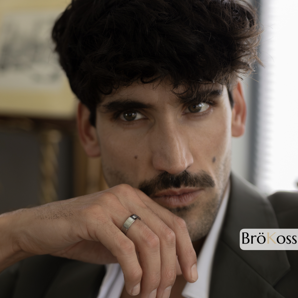 Hombre elegante con traje mostrando el anillo de promesa, símbolo de compromiso