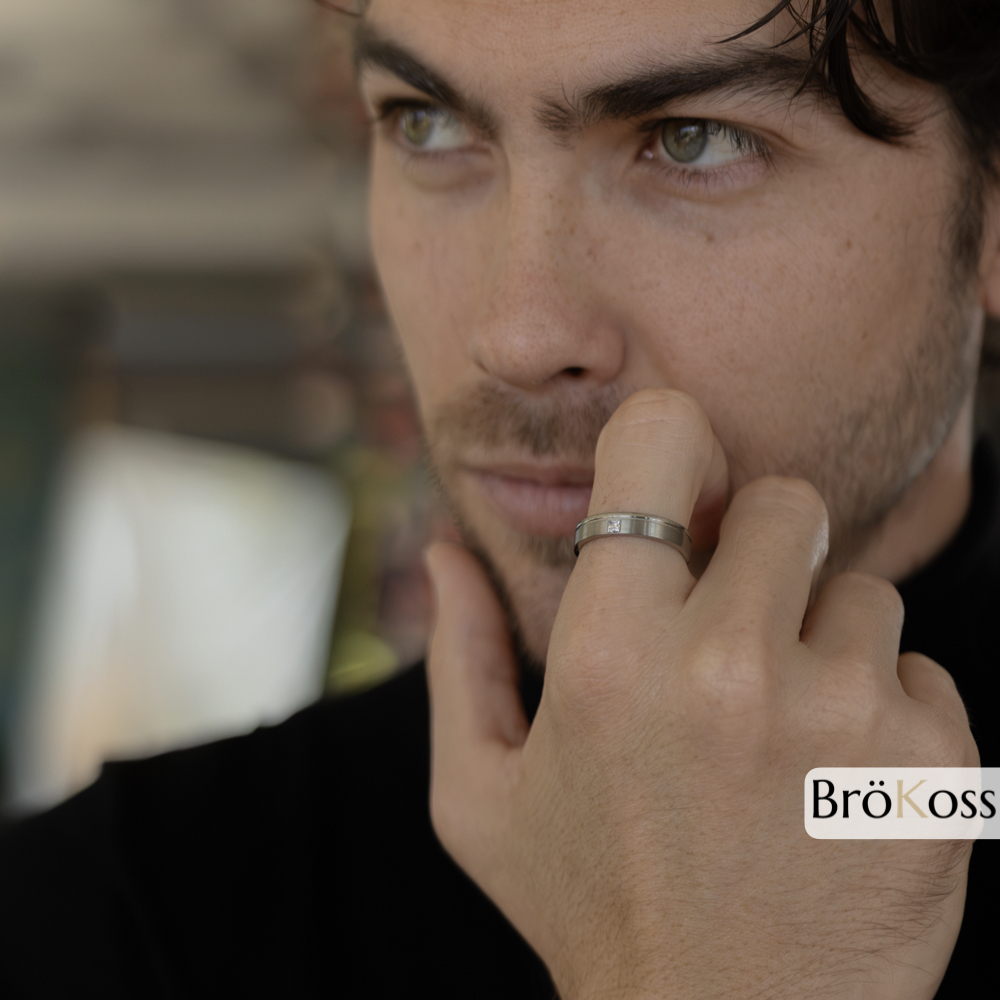 Anillo para pedirle matrimonio a un hombre con diamante, zirconio gris, primer plano del anillo con acabado moderno y elegante