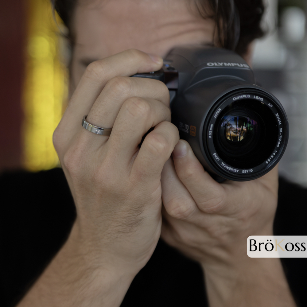 Anillo para pedirle matrimonio a un hombre, modelo haciéndose una foto con cámara mientras luce anillo de zirconio gris con diamante