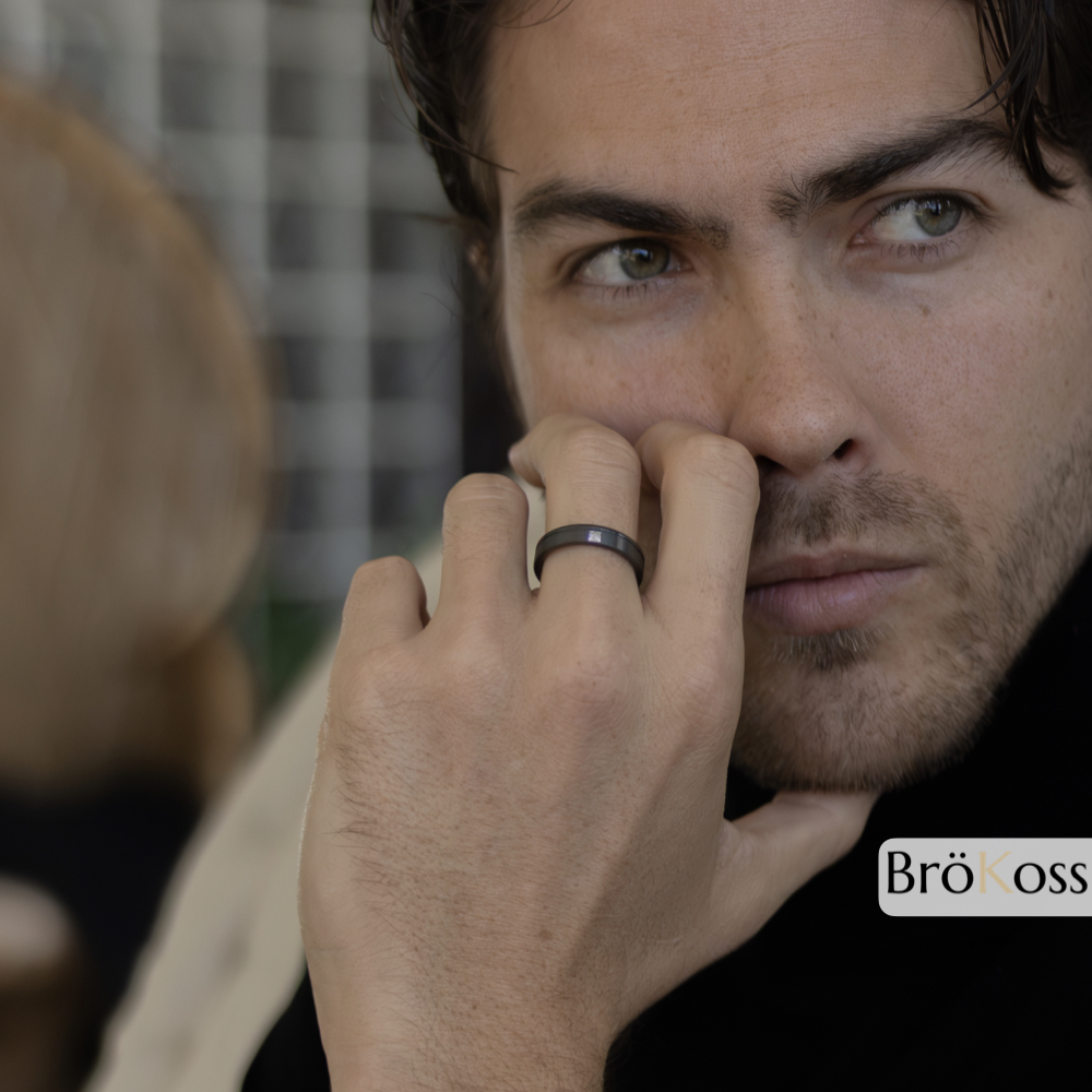 Modelo masculino mostrando alianza de hombre estilo oro en zirconio negro con brillante diamante en su mano