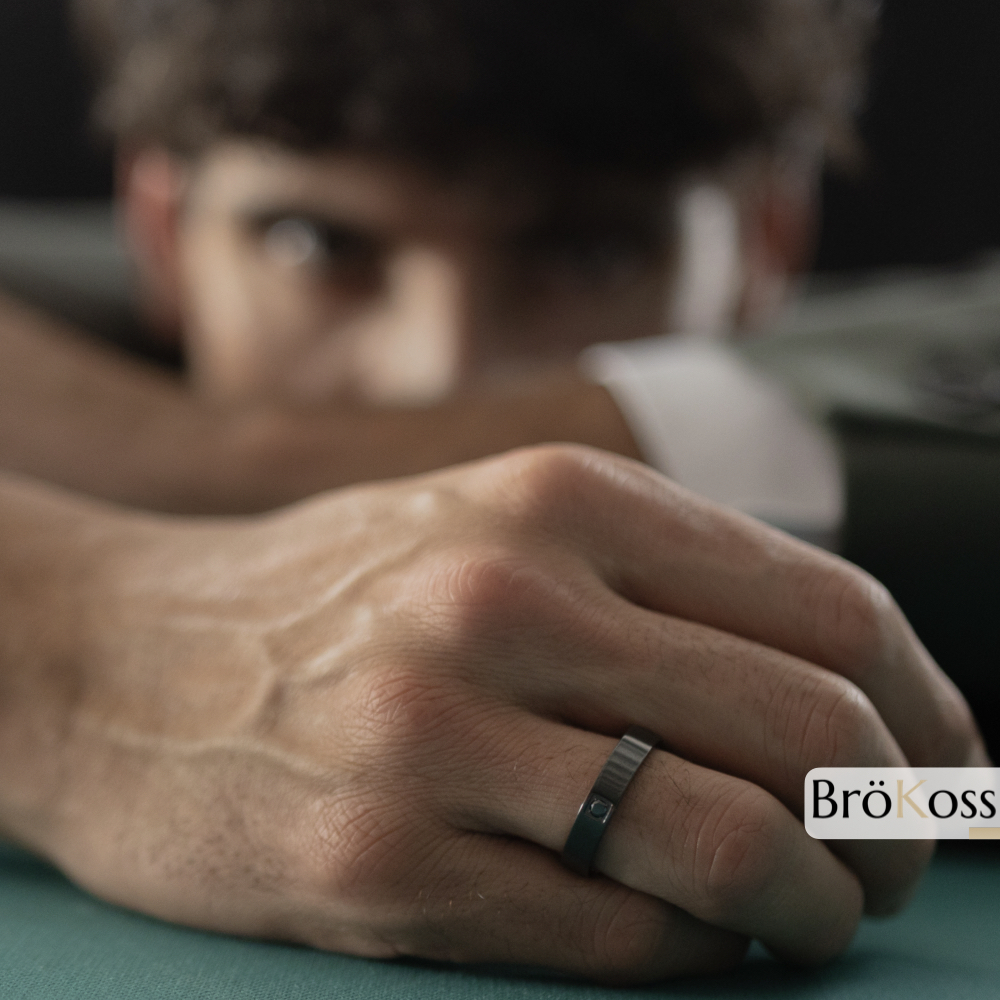 Anillo compromiso de hombre con diamante negro en mano de modelo masculino carismático, anillo negro
